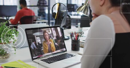 Sitting worker viewing colleague in yellow blazer on laptop screen at office desk, copy space