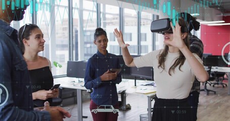 Demonstrating woman wearing VR headset gesturing forward in office, with smartphone and tablet