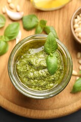 Fresh pesto sauce in jar on black table, top view