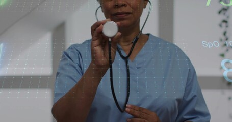 Presenting scrub-clad worker holding stethoscope chestpiece in exam room with vital sign overlay