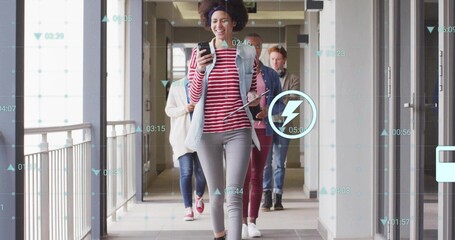 Walking colleague checking smartphone in office corridor, with digital overlays and tablet