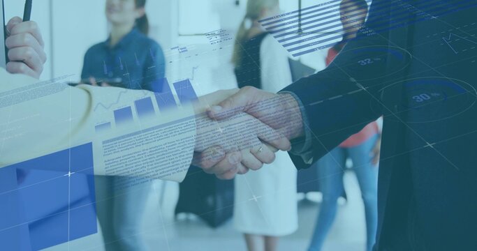 Shaking hands colleagues in business attire meeting in open-plan office, with smartphone and charts