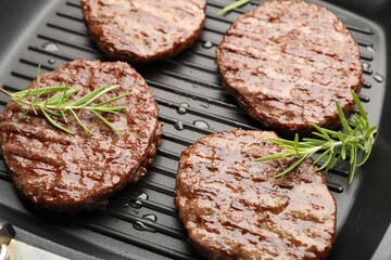 Pan with grilled patties and rosemary, closeup