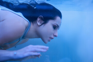 Underwater exploration by a young woman in a serene blue environment capturing tranquility