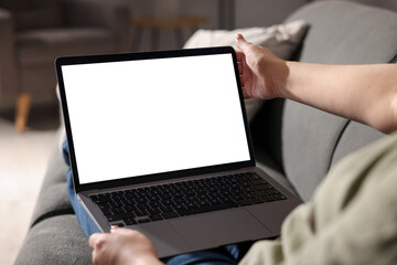Woman working with laptop on sofa indoors, closeup. Mockup for design