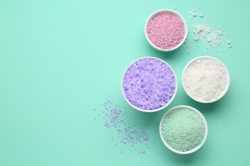 Different types of sea salt on turquoise background, flat lay. Space for text