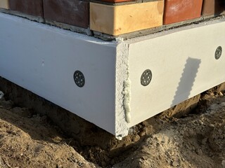 Foundation is insulated with expanded polystyrene closeup. Disc-shaped dowels for thermal insulation. Mounting foam