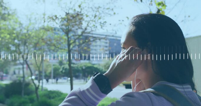 Woman inserting wired earbuds adjusting cables while audio waveform overlay visualizing music tech