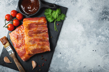 Ready for BBQ raw pork spare ribs with barbecue sauce. Black background. Top view