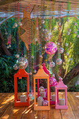 An enchanting seaside event decoration featuring traditional lanterns with flickering candles,...