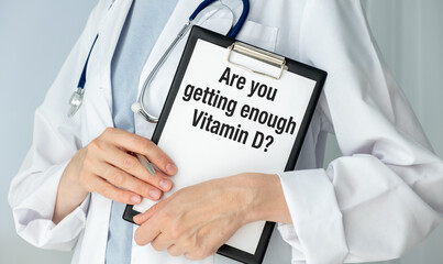A doctor holding a clipboard with the word Are you getting enough Vitamin D written on it.