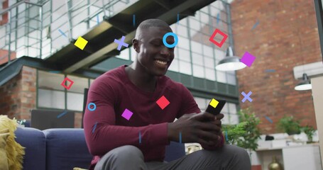 Man tapping smartphone and initiating shapes swirling around sofa marking technology success - Powered by Adobe