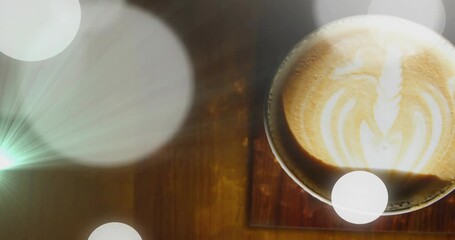 Point light emerging left, bokeh circles drifting onto latte cup lens flare illuminating leaf art - Powered by Adobe