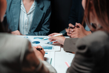 Business team engaging in discussion over financial charts and graphs, analyzing market growth during a collaborative meeting
