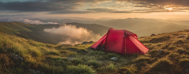 The Tent on a Mountain Ridge at Golden Sunrise with Misty Valley Views
