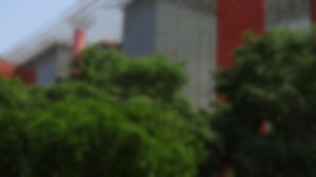 Blurred panoramic view of modern architecture of the commercial building in Connaught Place in Delhi, India, under clear blue summer sky. Bokeh real time motion video for background.