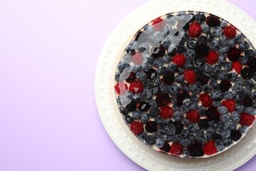 Delicious cheesecake with berries on violet background, top view. Space for text