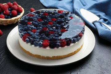 Delicious cheesecake with berries served on black textured table, closeup