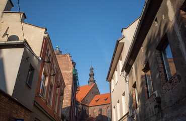 Obraz premium Szkolna Street, turret in background, blue sky opens up between houses (space for text). Gliwice, Poland.