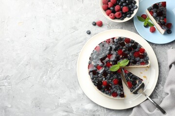 Taking piece of delicious cheesecake with berries at grey textured table, flat lay. Space for text