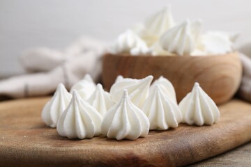Delicious meringue cookies on wooden table, closeup