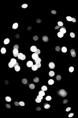 Festive black Christmas background made of glowing defocused garland with many lights. Christmas and New Year holidays template.