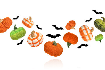 Knitted orange and green pumpkins with black bats on white background, autumn composition. Halloween concept.