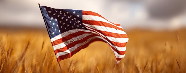 The American flag waving over golden wheat field under dramatic cloudy sky at sunset