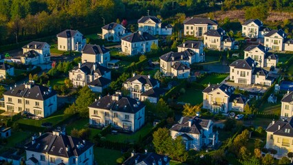 Obraz premium Luxury homes blending into the autumn landscape at sunrise.
