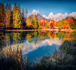 Attractive autumn scene of Welsperg lake in the middle of the autumn forest. Incredible morning view of Tonadico, Province of Trento, Italy, Europe. Exotic landscape of Dolomite Alps. 