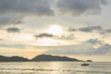 Obraz premium Blurry coastal sunset with clouds and silhouetted islands on tranquil ocean horizon.