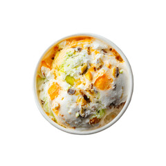 Top view of pistachio and mango ice cream with nuts in a cup. Gourmet Indian Kulfi style frozen dessert isolated on black background.