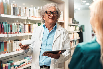 Pharmacist consulting customer in cosmetics aisle