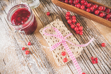 Red berries  with toast on wooden plate at retro concept. Top view