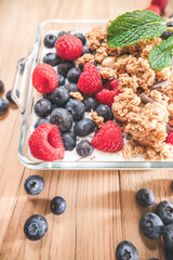 Breakfast of granola and wild berries. Delivered in a glass plate