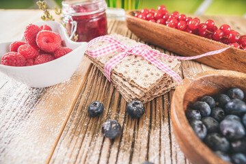 Decorated pastry sweet breakfast with berries and toast over wooden table.