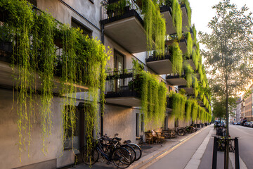 Green balconies of modern residential buildings, lush vertical landscaping and facade decoration with plants
