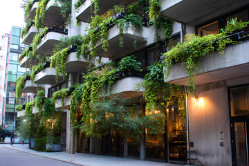 Green balconies of modern residential buildings, lush vertical landscaping and facade decoration with plants