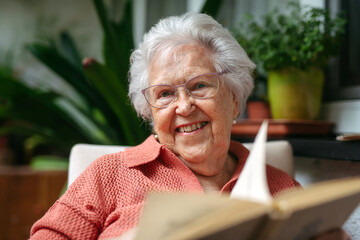 Senior lady sitting at balcony, reading book.