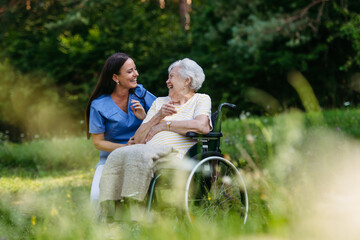 Home nurse taking care of elderly woman in wheelchair.