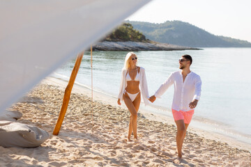 Couple enjoying a sunny day at the beach, embracing the summer vibes together