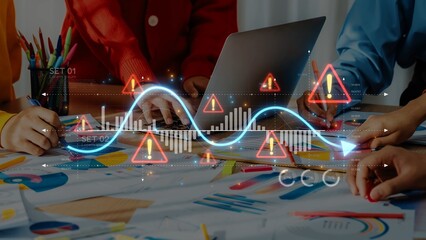 A dynamic team engages in data analysis with colorful stationery and warning signs overlaying graphs, emphasizing collaboration in a modern workspace. Raster