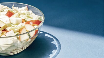 Fresh apple and lettuce salad in a glass bowl