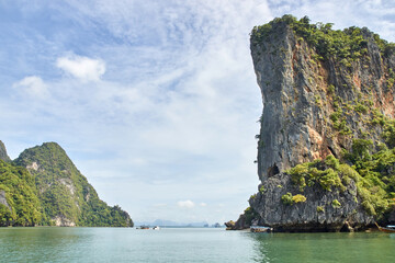 Obraz premium Scenic tropical limestone cliffs and calm sea in thailand s phang nga bay on a clear day.