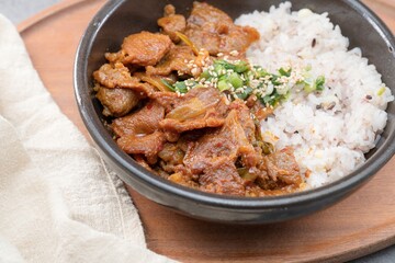 Jeyukdeopbap, Korean Food Spicy Stir-fried Pork with Rice in Black Bowl 