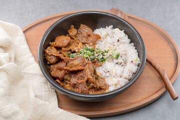 Jeyukdeopbap, Korean Food Spicy Stir-fried Pork with Rice in Black Bowl 