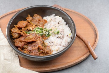 Jeyukdeopbap, Korean Food Spicy Stir-fried Pork with Rice in Black Bowl 