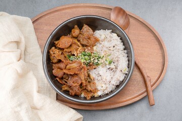 Jeyukdeopbap, Korean Food Spicy Stir-fried Pork with Rice in Black Bowl 