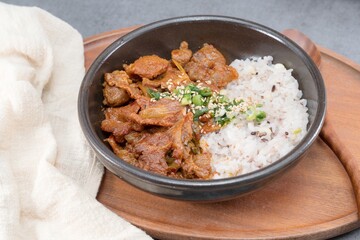 Jeyukdeopbap, Korean Food Spicy Stir-fried Pork with Rice in Black Bowl 