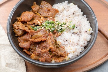 Jeyukdeopbap, Korean Food Spicy Stir-fried Pork with Rice in Black Bowl 